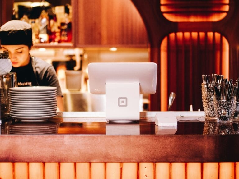 Modernes Kassensystem im Restaurant mit Servicemitarbeiterin im Hintergrund.