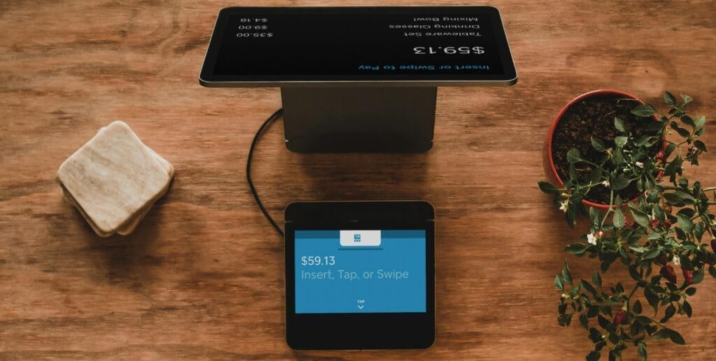 Eine Tablet-Kasse steht auf einem Tisch, davor steht ein Gerät zum kontaktlosen Bezahlen.